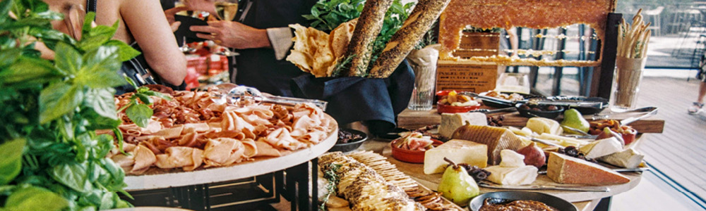 A buffet display of a farm-to-table catered appetizer and hors d'oeuvres style menu and food.